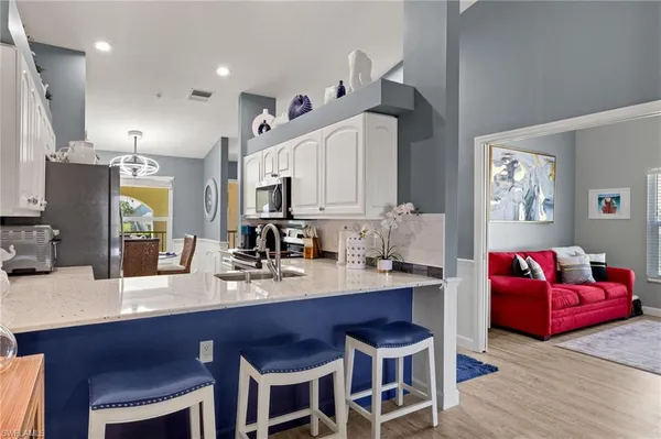 a kitchen with granite countertop a table chairs stove a sink and dishwasher