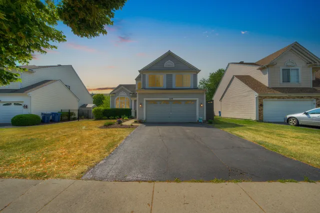 a front view of a house with a yard and garage