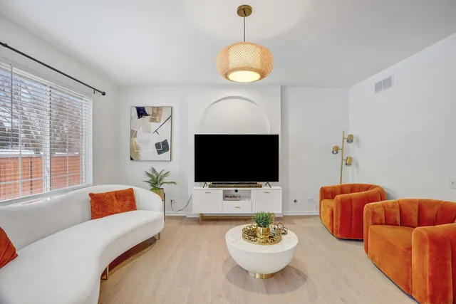 a living room with furniture a flat screen tv and a large window