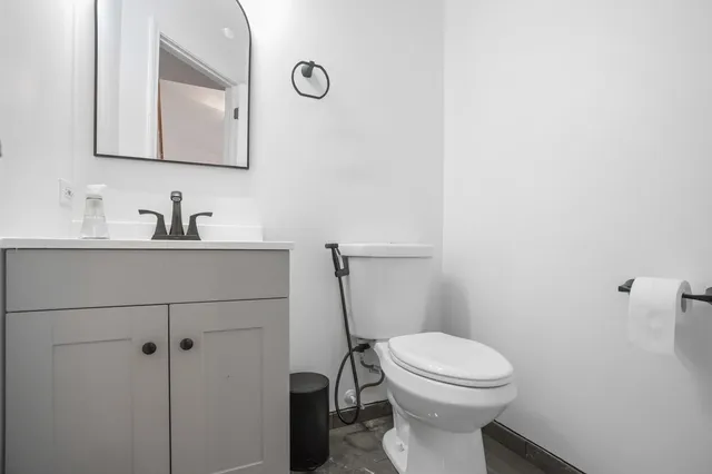 a bathroom with a toilet sink and mirror