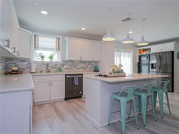 a kitchen with a sink cabinets a counter top space and stainless steel appliances