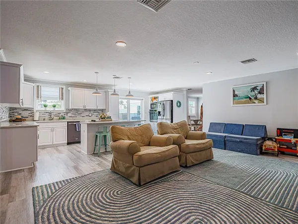 a living room with furniture and a view of kitchen