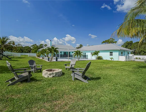 a view of a house with a yard table and chairs