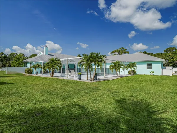 a view of a house with a big yard and a large tree