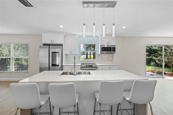 a kitchen with stainless steel appliances granite countertop a kitchen island a stove and a sink