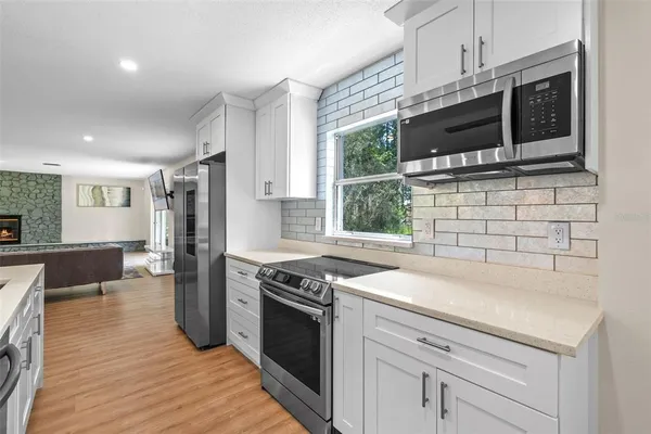 a kitchen with stainless steel appliances a stove a sink and a microwave