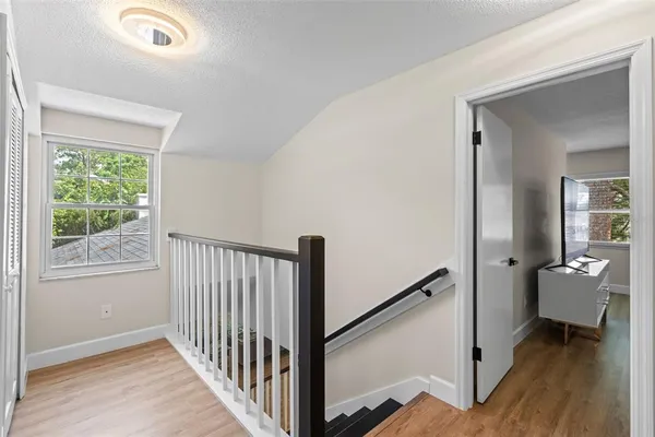 a view of a hallway with a white walls and wooden floor
