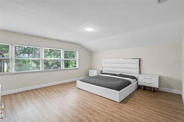 a spacious bedroom with a bed and a large window