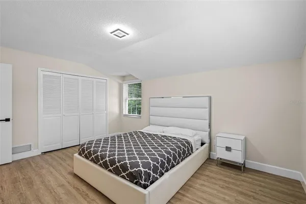 a bedroom with a bed and wooden floor