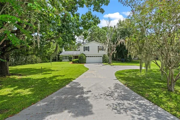 a front view of a house with a yard and trees