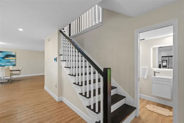 a view of staircase with wooden floor and a rug