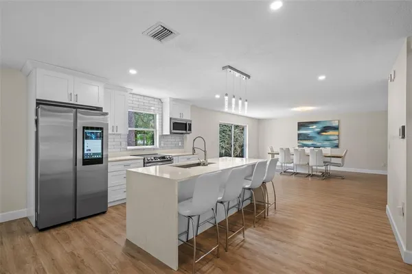 a view of kitchen with stainless steel appliances granite countertop a stove and a refrigerator