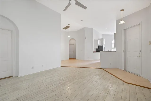 a view of empty room with wooden floor and window