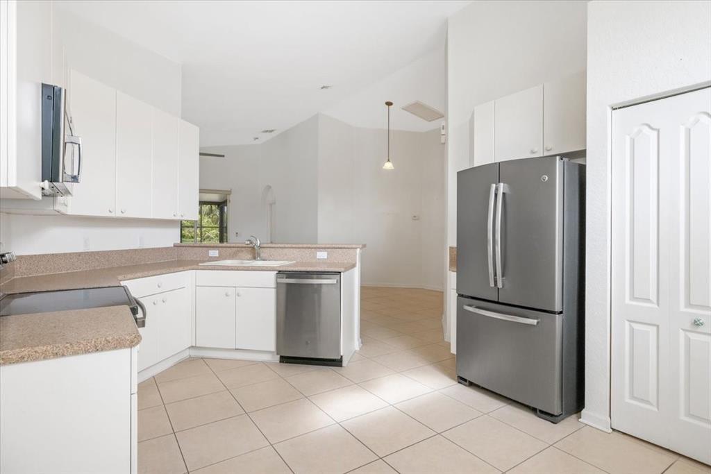 6300 Spring Lake Terrace Fort Pierce, FL 34951 - Photo 30 of 54 a kitchen with a refrigerator sink and cabinets