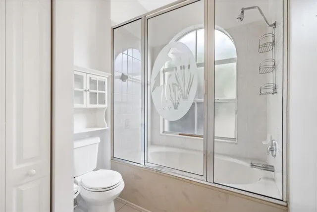 a bathroom with a glass shower door and a toilet