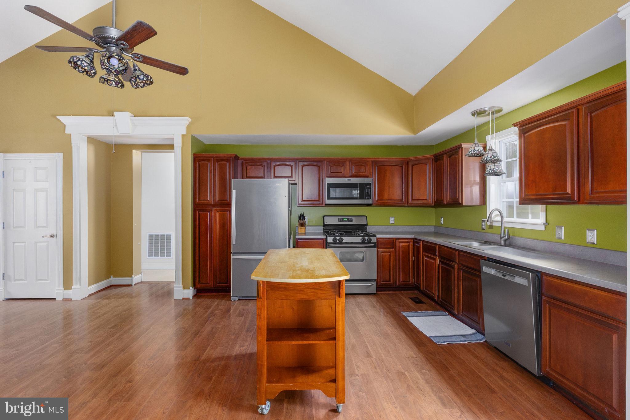 8314 Myrtle Lane King George, VA 22485 - Photo 14 of 40 a room with stainless steel appliances kitchen island granite countertop a refrigerator a stove top oven a sink and dishwasher