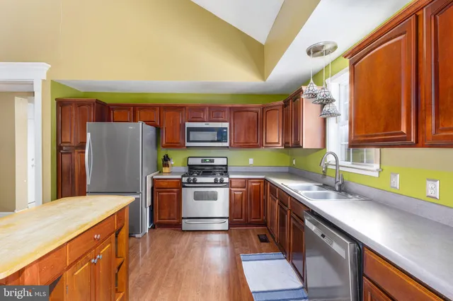 a kitchen with stainless steel appliances granite countertop a refrigerator stove microwave and sink