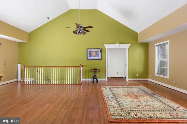 a view of a room with wooden floor and a table