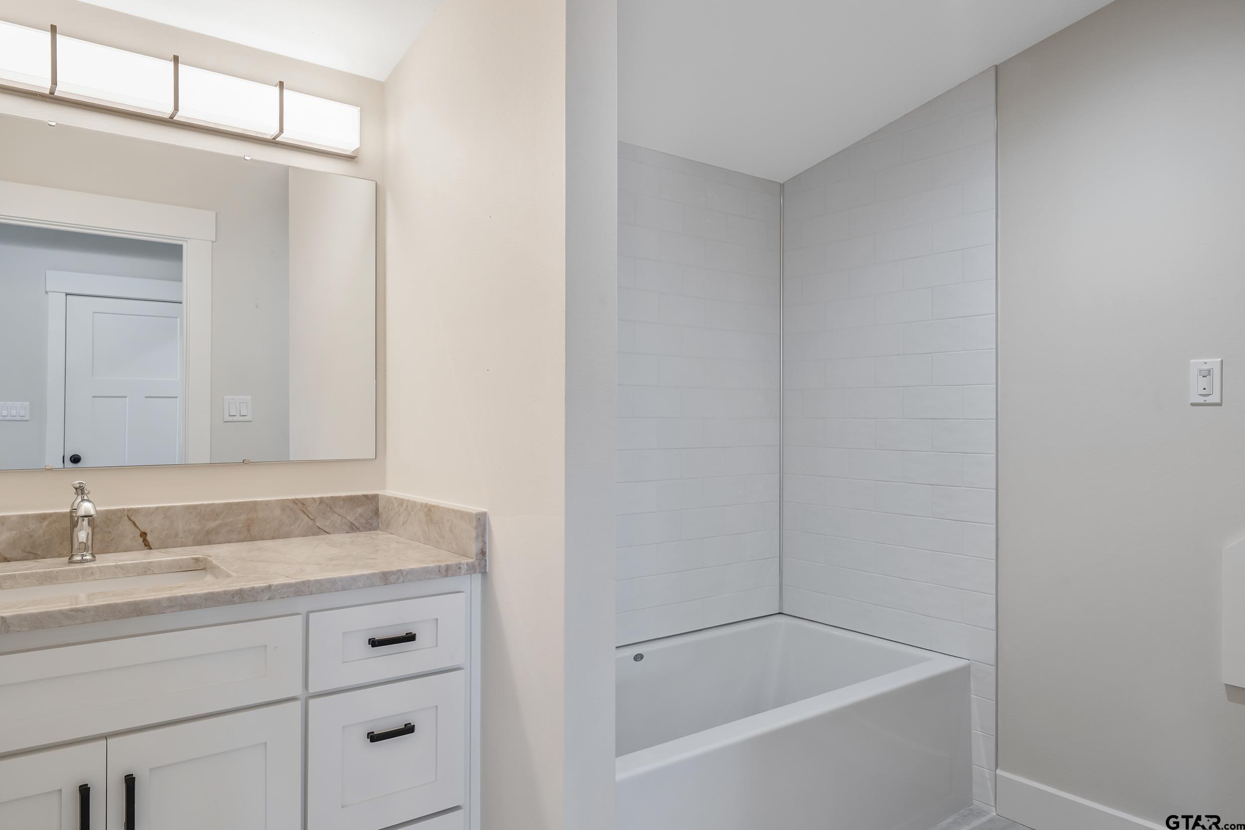 16919 Sawyer Way Lindale, TX 75771 - Photo 31 of 43 a bathroom with a granite countertop sink and a bathtub