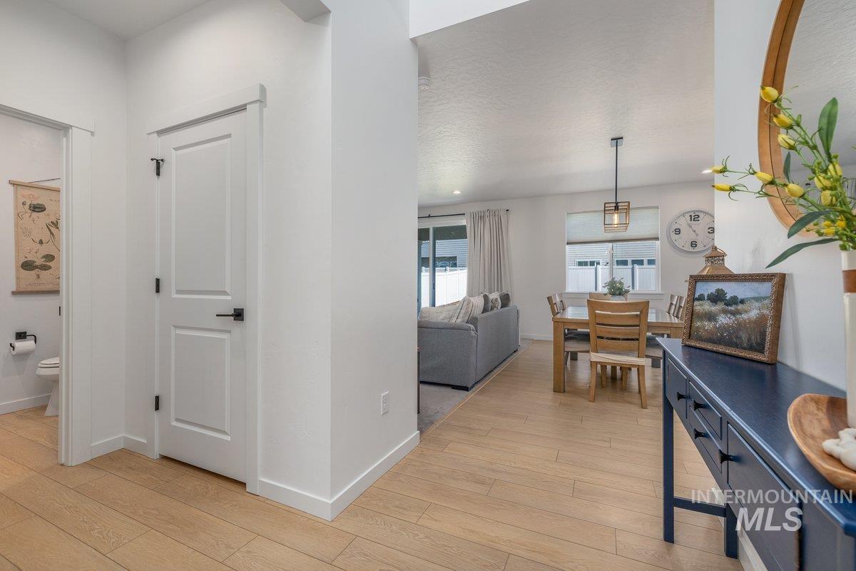 1380 West Chilitna Street Meridian, ID 83642 - Photo 23 of 50 Open-concept dining and living area featuring wood-finish flooring, recessed lighting, and a modern pendant light fixture