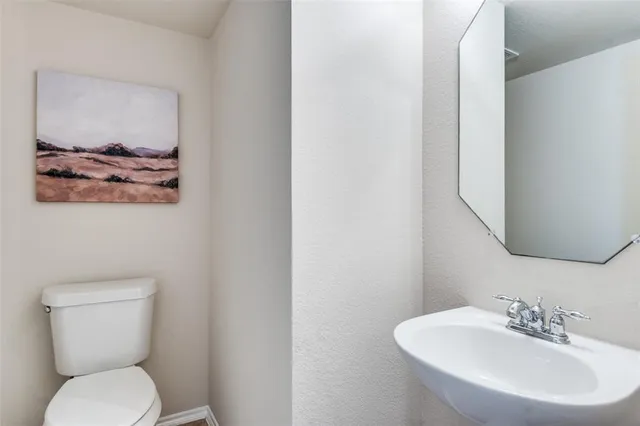 a bathroom with a toilet a sink and mirror