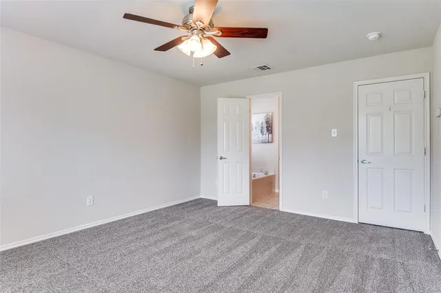 an empty room with closet and a chandelier fan
