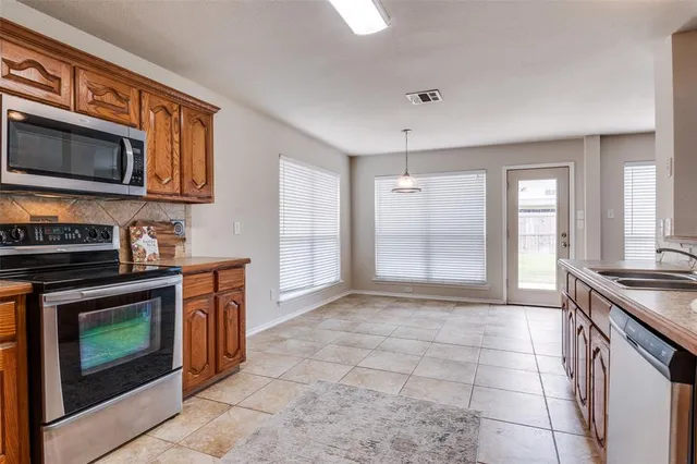 a kitchen with stainless steel appliances granite countertop a stove microwave and sink