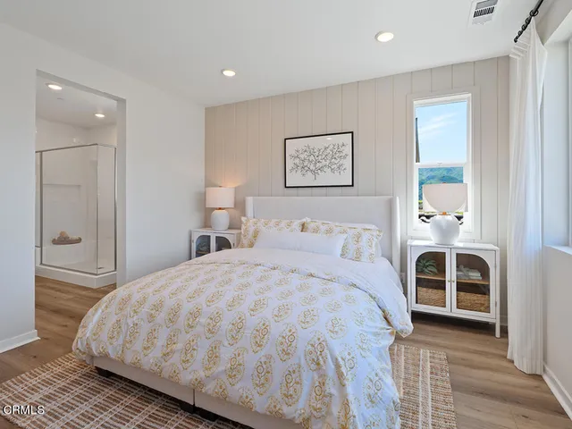 a bedroom with a large bed and a chandelier