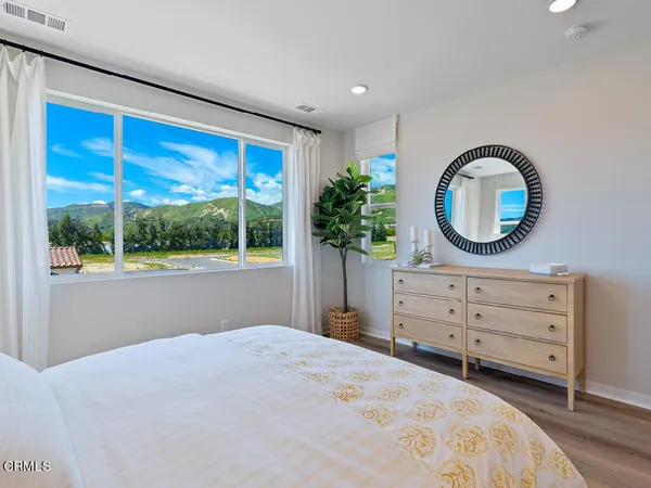 a bedroom with a bed and a large window