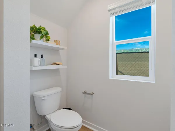 a white toilet sitting next to a bathroom sink and vanity