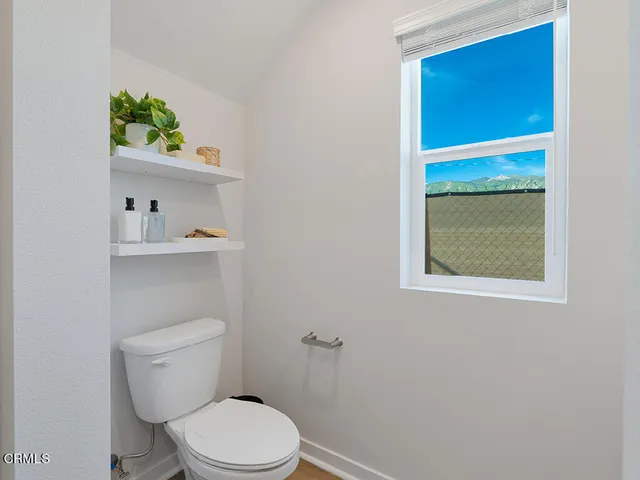 a white toilet sitting next to a bathroom sink and vanity