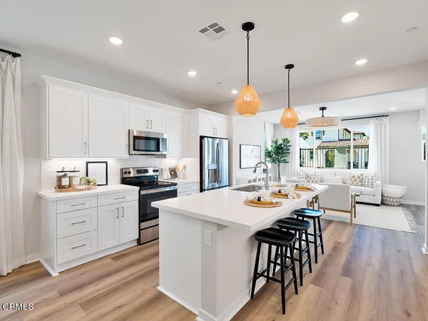 a open kitchen with white cabinets and stainless steel appliances