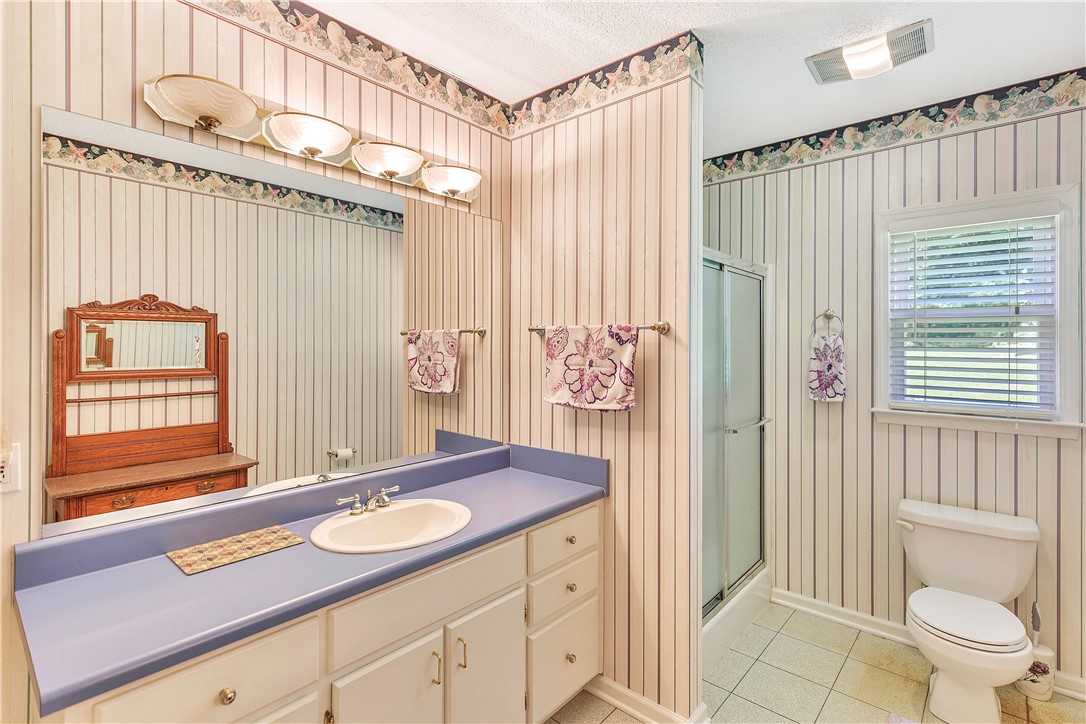 910 Chantilly Lane Anderson, SC 29625 - Photo 15 of 38 A classic primary bathroom vanity provides ample storage and counter space, complemented by a convenient walk-in shower.