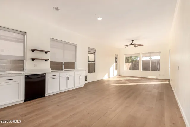 a large white kitchen with granite countertop a stove a sink and a refrigerator