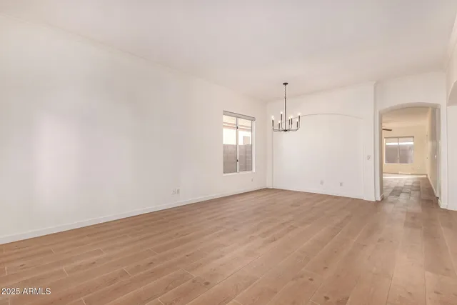 a view of empty room with wooden floor and ceiling fan