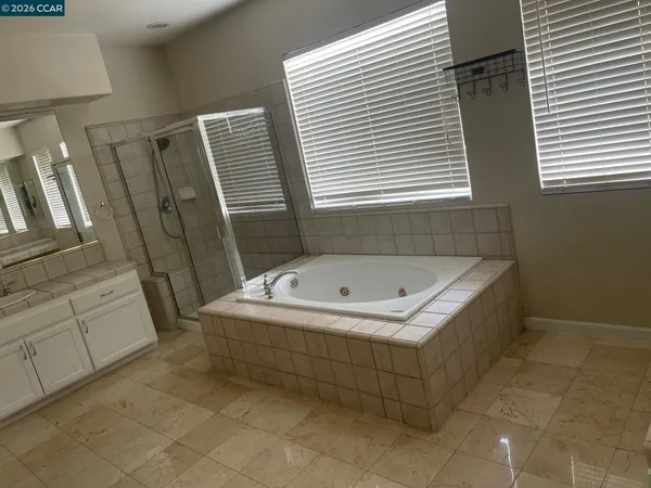 a bathroom with a tub sink and mirror