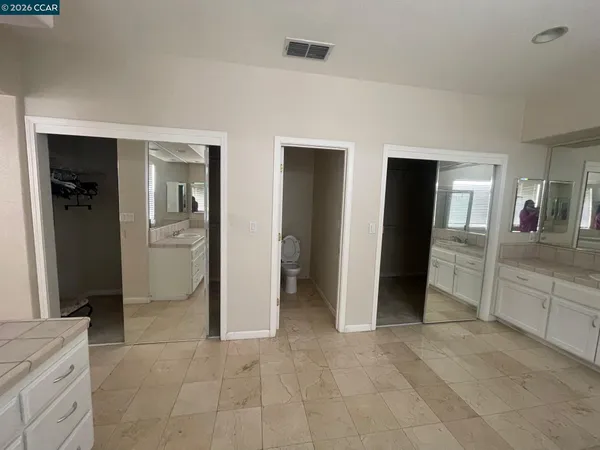 a view of a hallway with a livingroom and a bathroom with sink