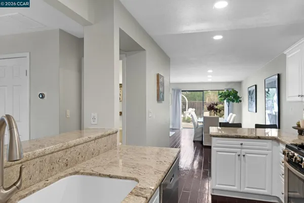 a kitchen with granite countertop a sink stove and refrigerator