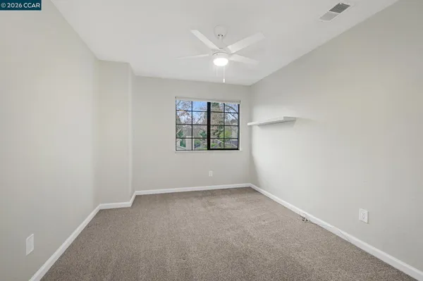 an empty room with windows and closet