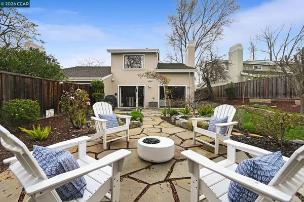 a front view of a house with patio furniture and potted plants
