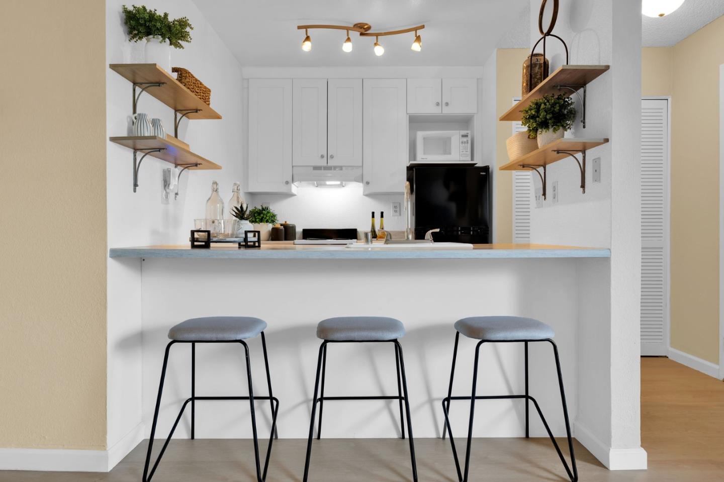244 Stonegate Circle San Jose, CA 95110 - Photo 9 of 38 a kitchen with stainless steel appliances kitchen island a table chairs in it and white cabinets