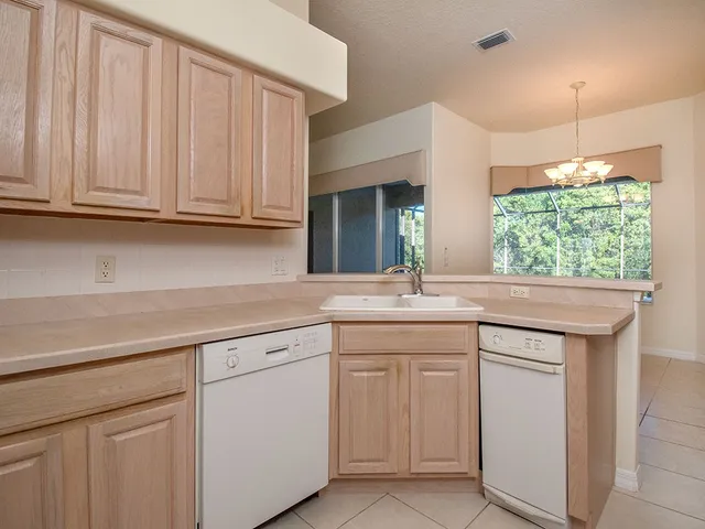 a kitchen with white cabinets and sink