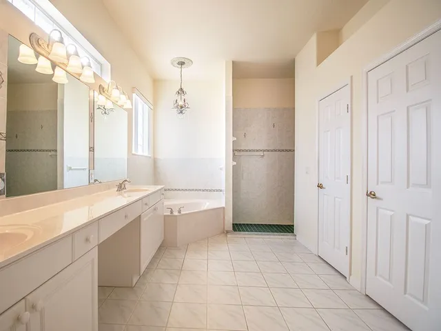 a bathroom with a granite countertop sink a mirror and a bathtub