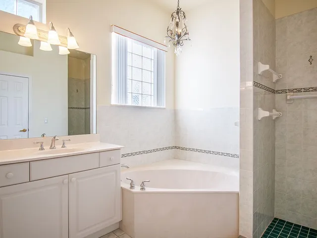 a bathroom with a tub sink and mirror