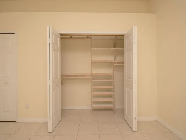 a view of walk in closet with empty racks