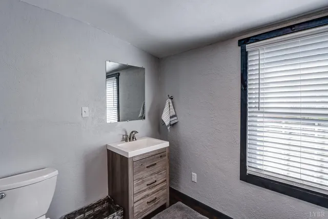 a bathroom with a toilet sink and mirror