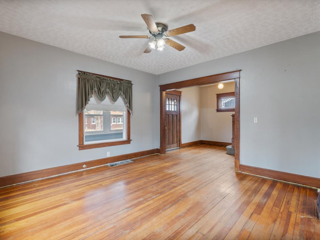 2416 21st Avenue Rock Island, IL 61201 - Photo 15 of 26 a view of an empty room with wooden floor and a window