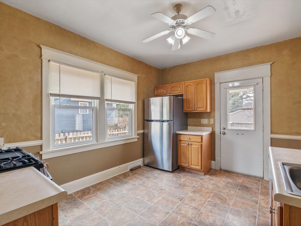 2416 21st Avenue Rock Island, IL 61201 - Photo 20 of 26 a view of a kitchen with a stove cabinets a ceiling fan and wooden floor