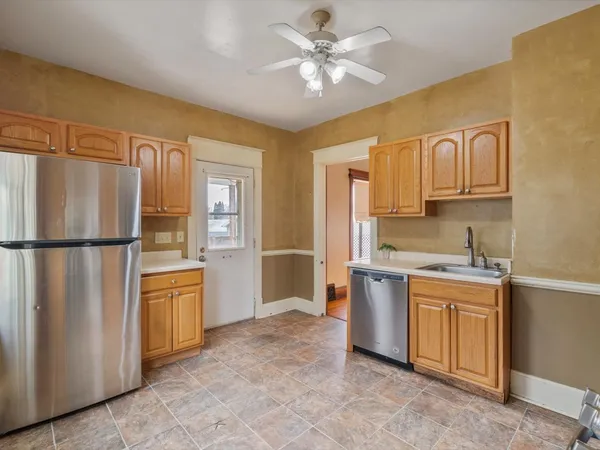 a kitchen with stainless steel appliances granite countertop a refrigerator a stove and a sink