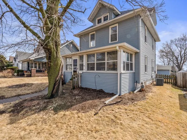 a front view of a house with a yard covered in snow